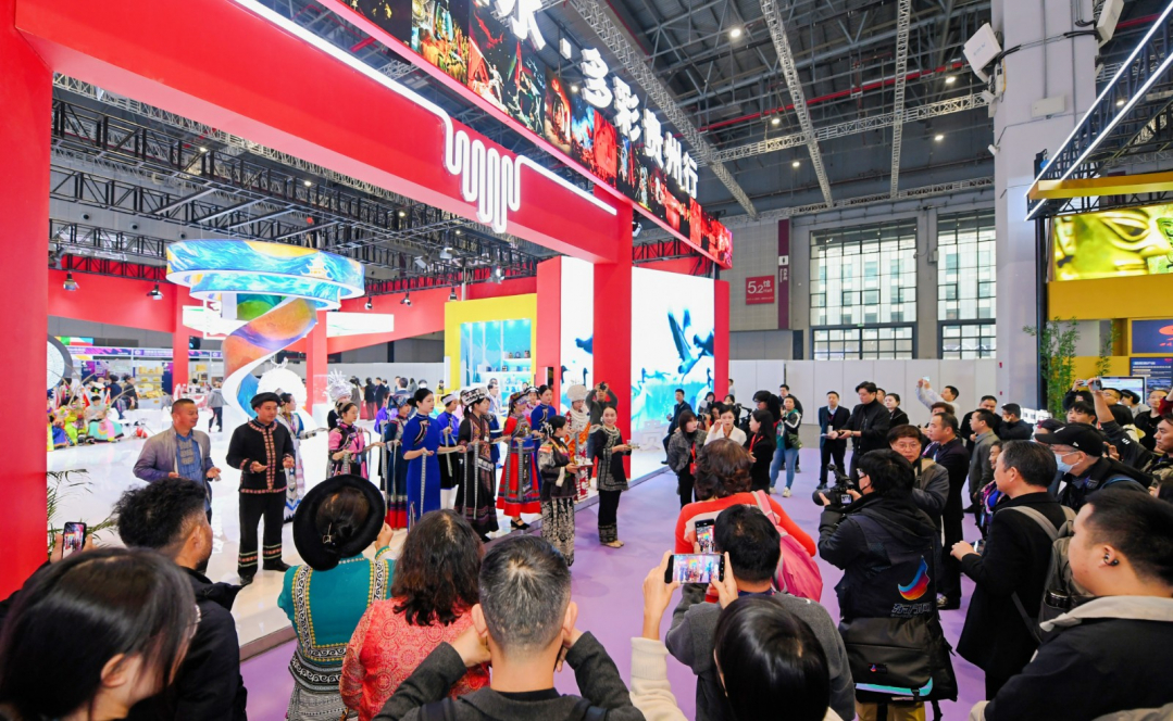 wen_4179---贵州展馆开馆首日，为第一批逛展观众送上了少数民族花带等.jpg